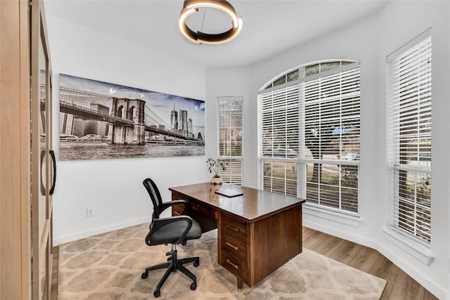 home office featuring baseboards and wood finished floors