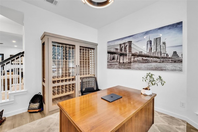 home office featuring visible vents, a city view, baseboards, and wood finished floors