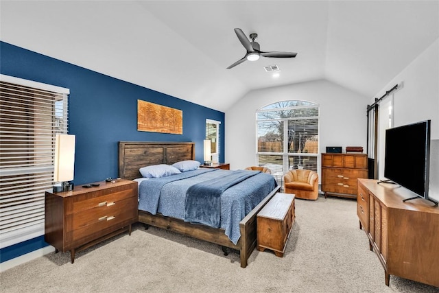 bedroom with visible vents, a barn door, vaulted ceiling, light carpet, and a ceiling fan