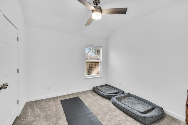 exercise area featuring a ceiling fan, vaulted ceiling, carpet, and baseboards