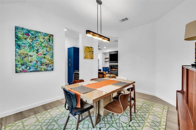 dining space with visible vents, baseboards, and light wood-style floors