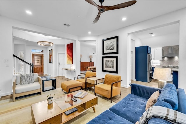 living area with baseboards, visible vents, light wood finished floors, recessed lighting, and ceiling fan