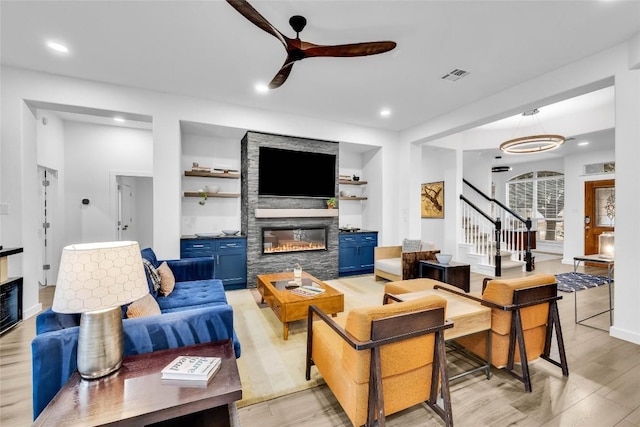 living room featuring a ceiling fan, visible vents, recessed lighting, light wood-type flooring, and a large fireplace