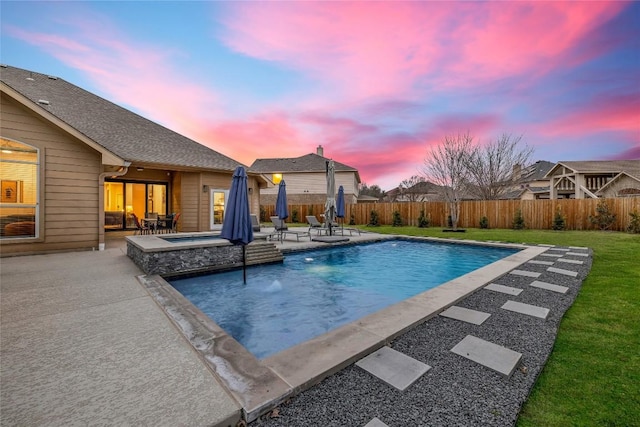 pool at dusk with a patio, a fenced in pool, an in ground hot tub, a yard, and a fenced backyard