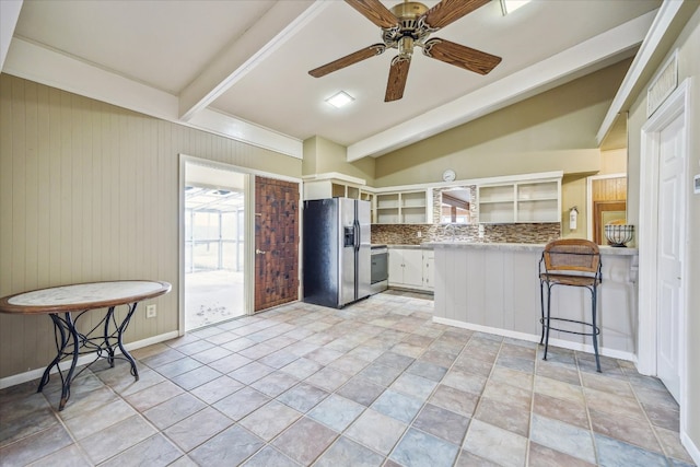 kitchen featuring a breakfast bar, a ceiling fan, a peninsula, white cabinets, and stainless steel fridge with ice dispenser