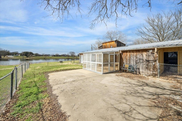 exterior space with a water view, an outdoor structure, and fence