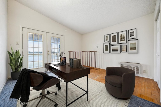 home office with french doors, wood finished floors, a textured ceiling, and vaulted ceiling