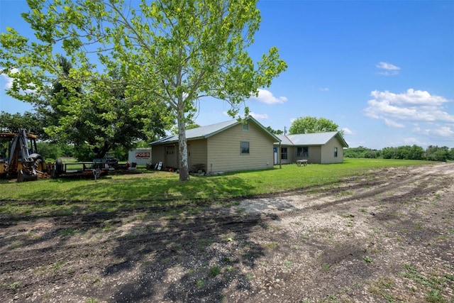 exterior space with a yard and dirt driveway