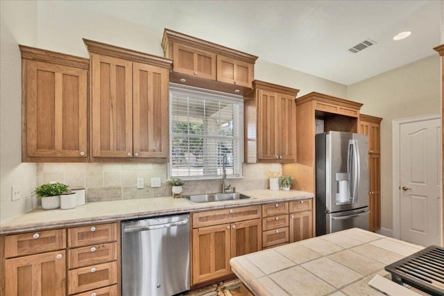 kitchen featuring a sink, stainless steel appliances, tasteful backsplash, and visible vents