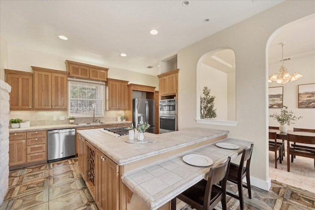 kitchen with a sink, recessed lighting, stainless steel appliances, tile countertops, and decorative backsplash