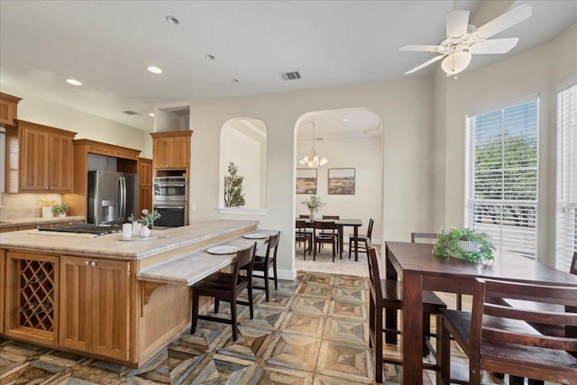 kitchen featuring visible vents, recessed lighting, stainless steel appliances, arched walkways, and decorative backsplash