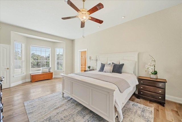 bedroom with baseboards, a ceiling fan, and light wood finished floors