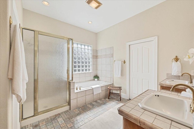 full bath featuring vanity, a shower stall, a garden tub, and recessed lighting