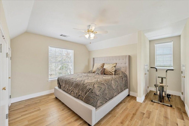 bedroom with visible vents, baseboards, lofted ceiling, light wood-style flooring, and a ceiling fan