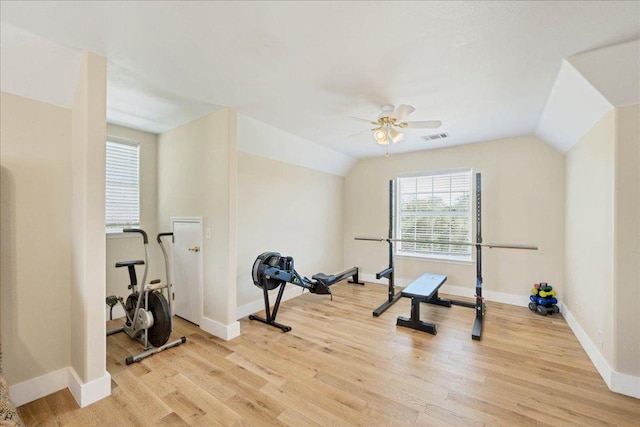 exercise area featuring visible vents, baseboards, vaulted ceiling, light wood-style floors, and a ceiling fan