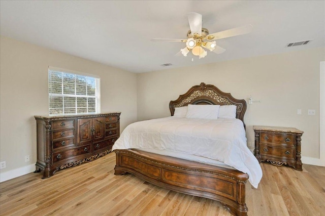 bedroom featuring visible vents, light wood-type flooring, and baseboards