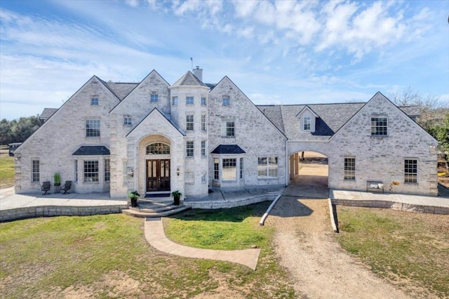 french provincial home with french doors, stone siding, and a patio area