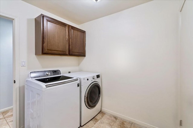 laundry area featuring baseboards, cabinet space, and washing machine and dryer