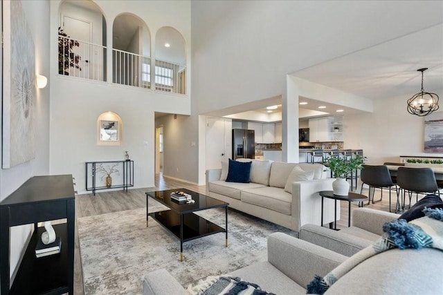 living room with a notable chandelier, wood finished floors, and recessed lighting