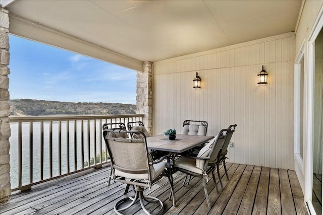 wooden deck with outdoor dining area and a water view