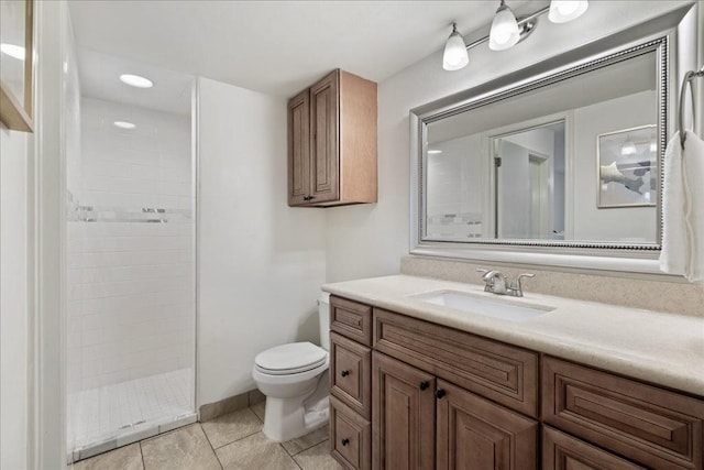 full bath featuring vanity, tile patterned floors, toilet, and tiled shower