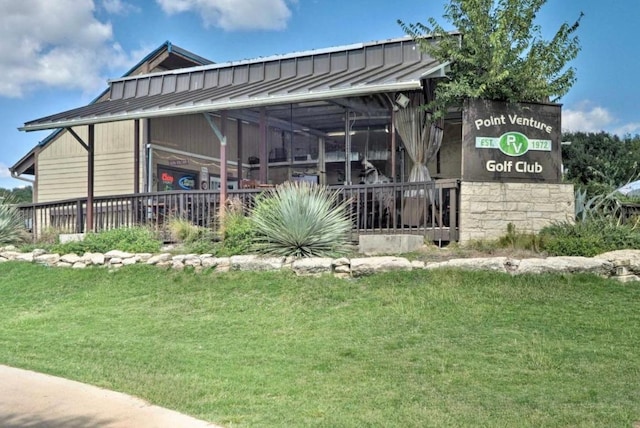 exterior space featuring a yard, metal roof, and a standing seam roof