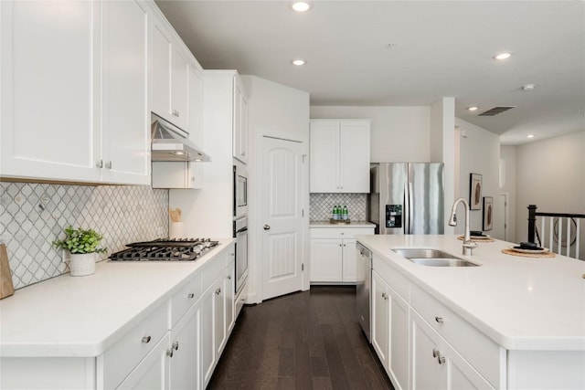 kitchen with visible vents, a sink, under cabinet range hood, stainless steel appliances, and dark wood-style flooring