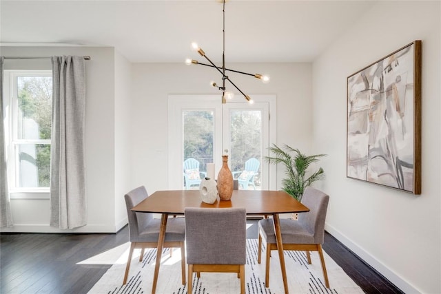 dining area with dark wood-style floors, baseboards, and an inviting chandelier