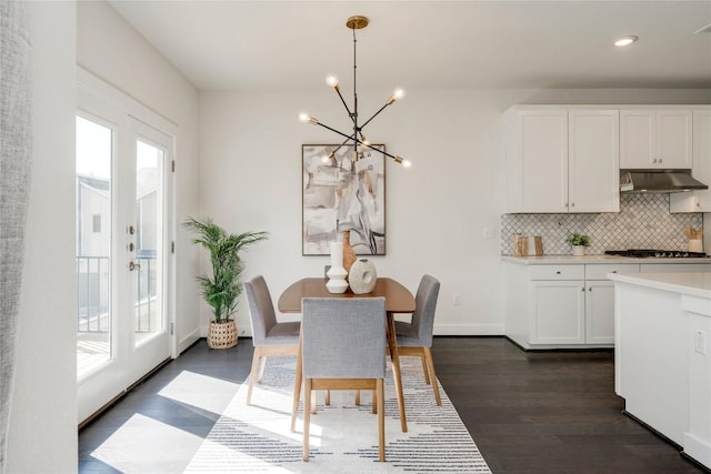 dining space featuring a chandelier, dark wood-style floors, baseboards, and a wealth of natural light