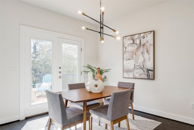 dining room featuring a wealth of natural light, baseboards, an inviting chandelier, and wood finished floors