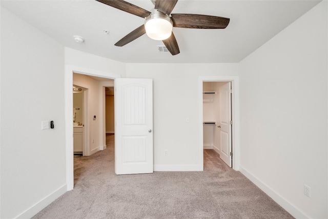 unfurnished bedroom featuring visible vents, carpet floors, baseboards, ceiling fan, and a spacious closet