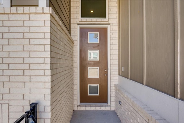 view of exterior entry with brick siding