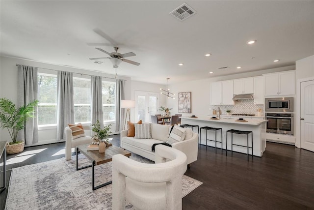 living area with ceiling fan, visible vents, dark wood-style floors, and recessed lighting