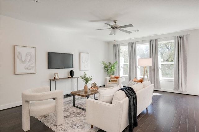 living room with visible vents, baseboards, ceiling fan, and dark wood-style flooring