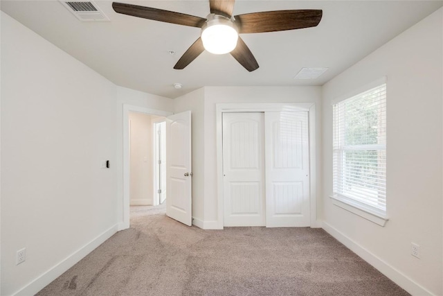 unfurnished bedroom with light carpet, visible vents, a closet, and baseboards