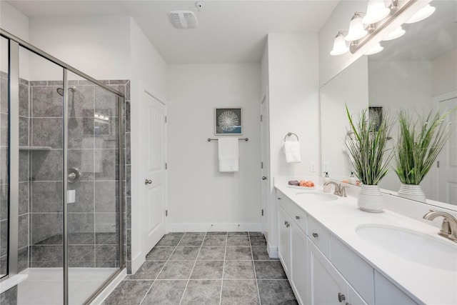 full bathroom featuring double vanity, tile patterned flooring, a shower stall, and a sink