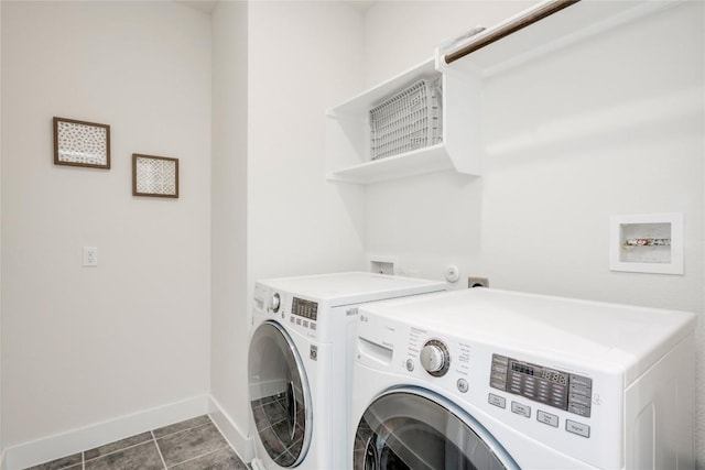 washroom featuring laundry area, dark tile patterned floors, baseboards, and washer and clothes dryer