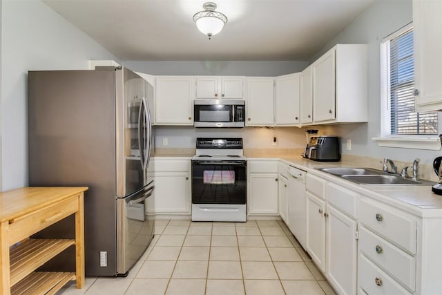 kitchen with light tile patterned flooring, white cabinetry, stainless steel appliances, and light countertops