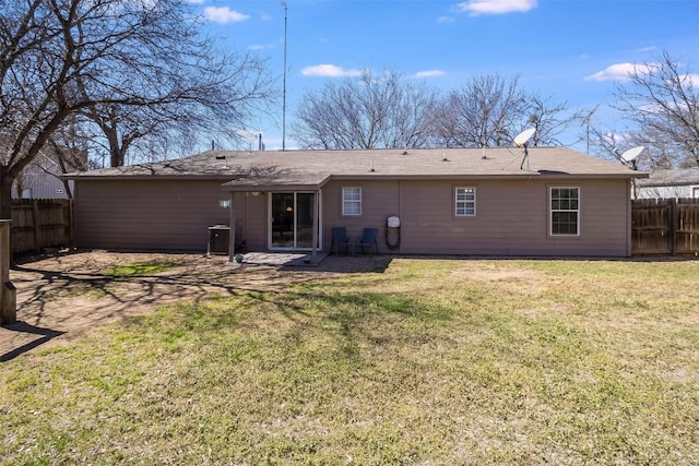 rear view of property featuring a lawn, a patio, and fence