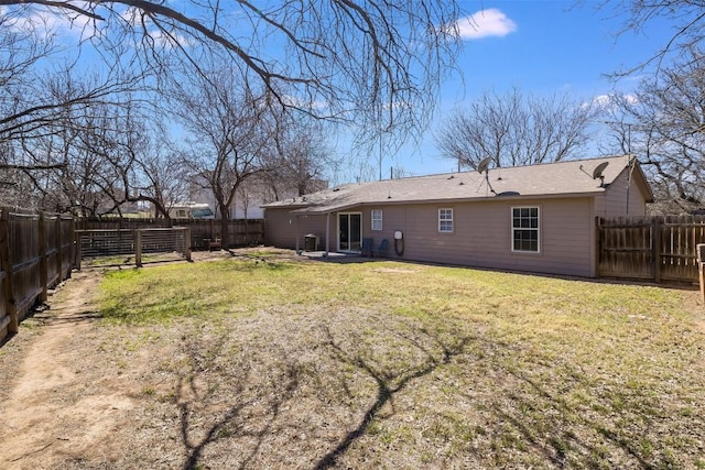 rear view of property with a lawn and a fenced backyard