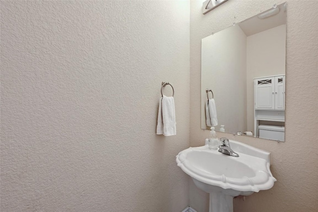 bathroom with a sink and a textured wall