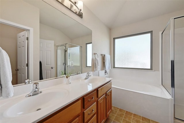 bathroom featuring a shower stall, a garden tub, double vanity, vaulted ceiling, and a sink