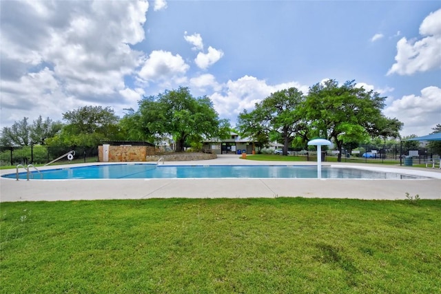 community pool with a lawn and fence