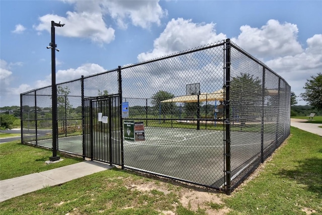 view of sport court with a gate, community basketball court, and fence