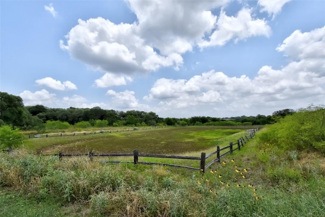 view of property's community featuring a rural view and fence