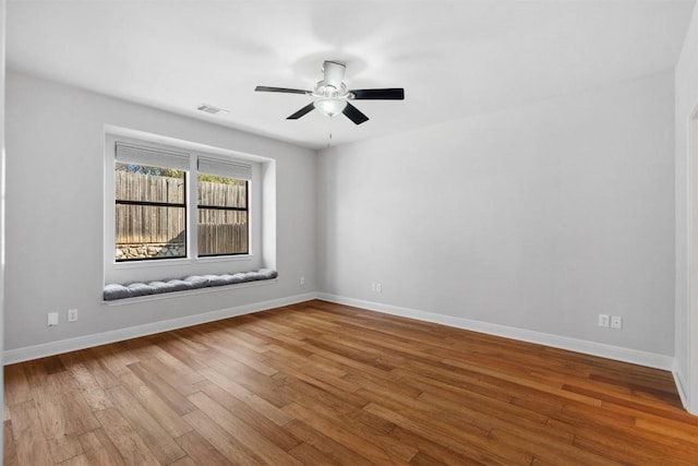 empty room featuring visible vents, baseboards, and hardwood / wood-style floors