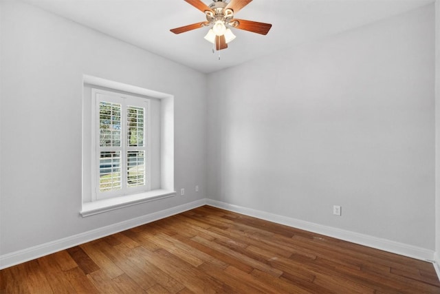 spare room featuring a ceiling fan, wood finished floors, and baseboards