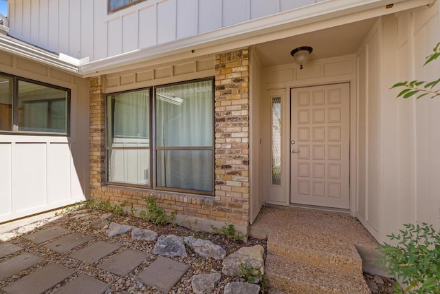 property entrance featuring brick siding and board and batten siding