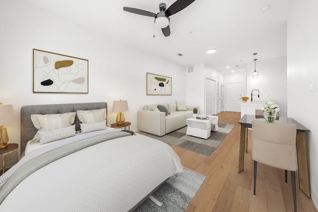 bedroom featuring a ceiling fan, visible vents, recessed lighting, a sink, and light wood-type flooring