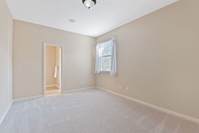 carpeted spare room featuring baseboards